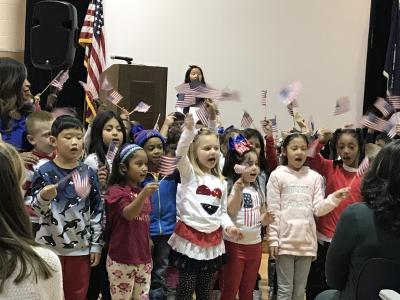 first graders singing and waving flags